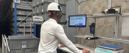 Técnico con casco revisando un equipo en el almacén